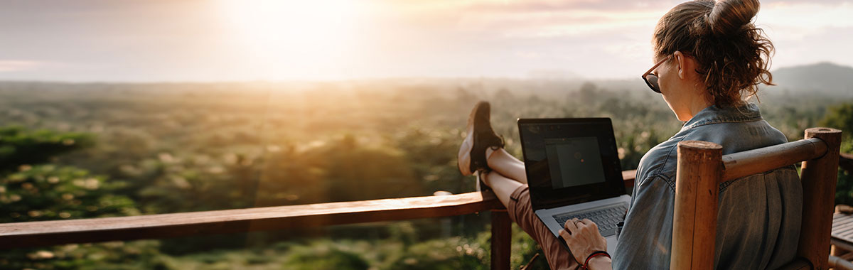 person sitting on vacation rental deck with computer